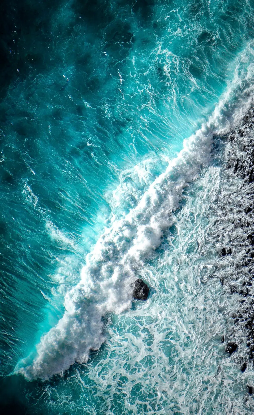 Aerial view of a wave breaking on the shore